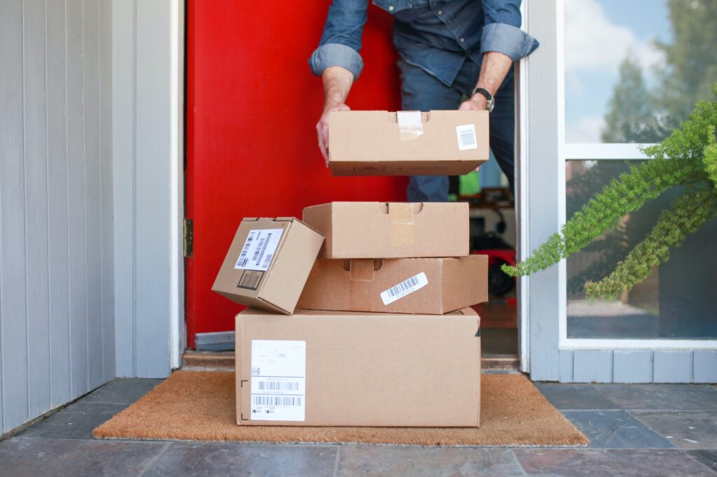 Man picking up delivered packages from the porch