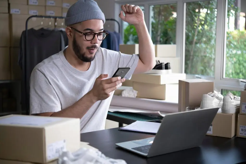 man looking to his phone and won a deal through his running business from home corner