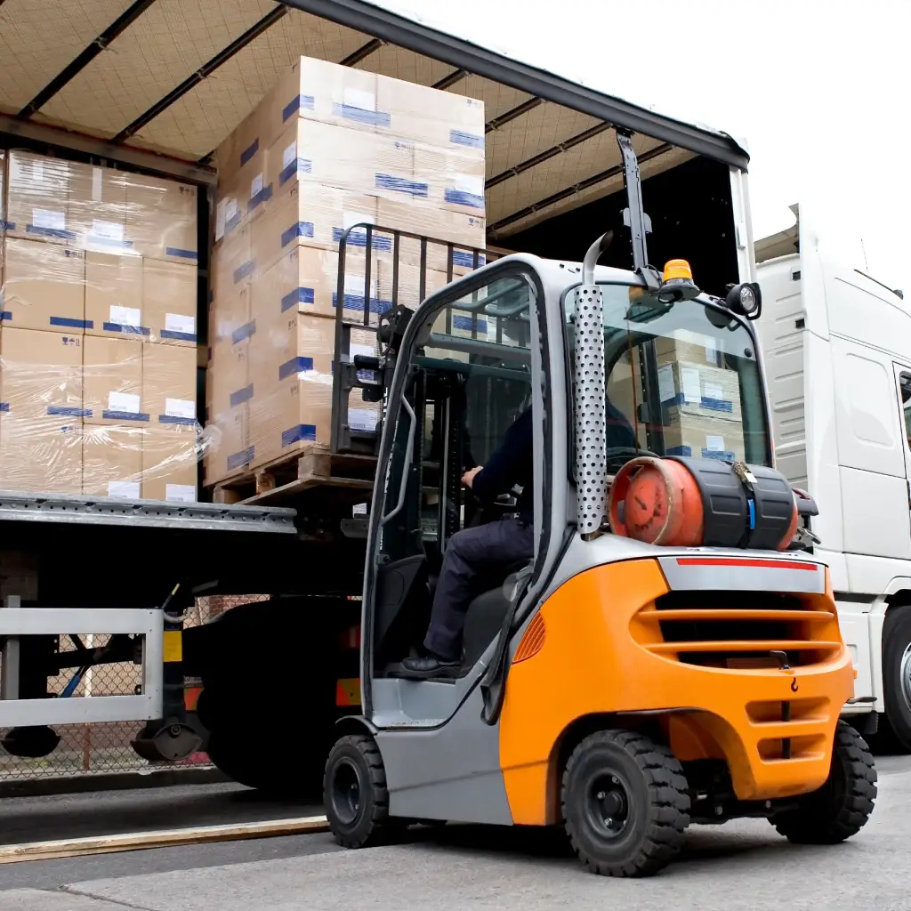 Forklift loading curtained trailer with stacked pallets with cartoned goods - Freight forwarding 